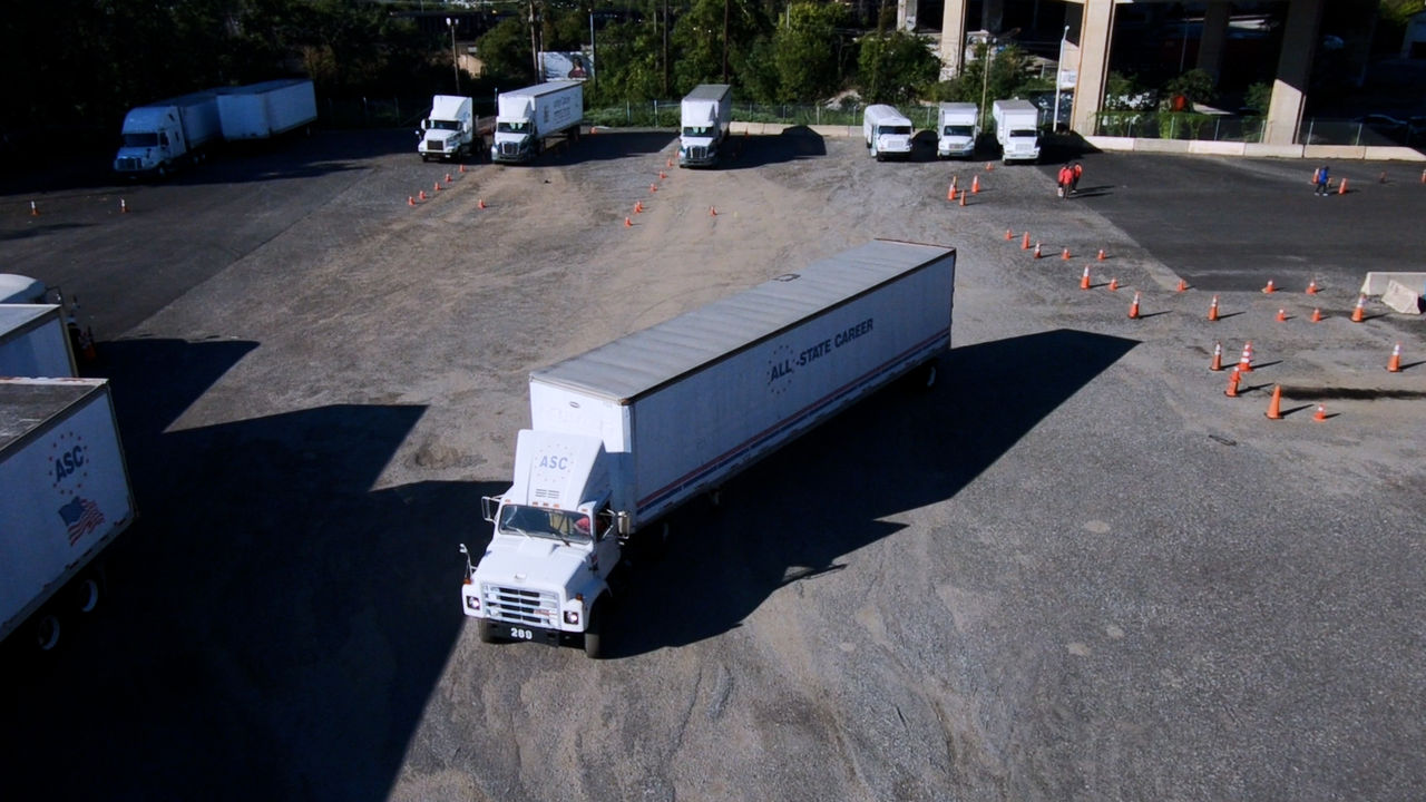 Large white semi truck in training lot with cones