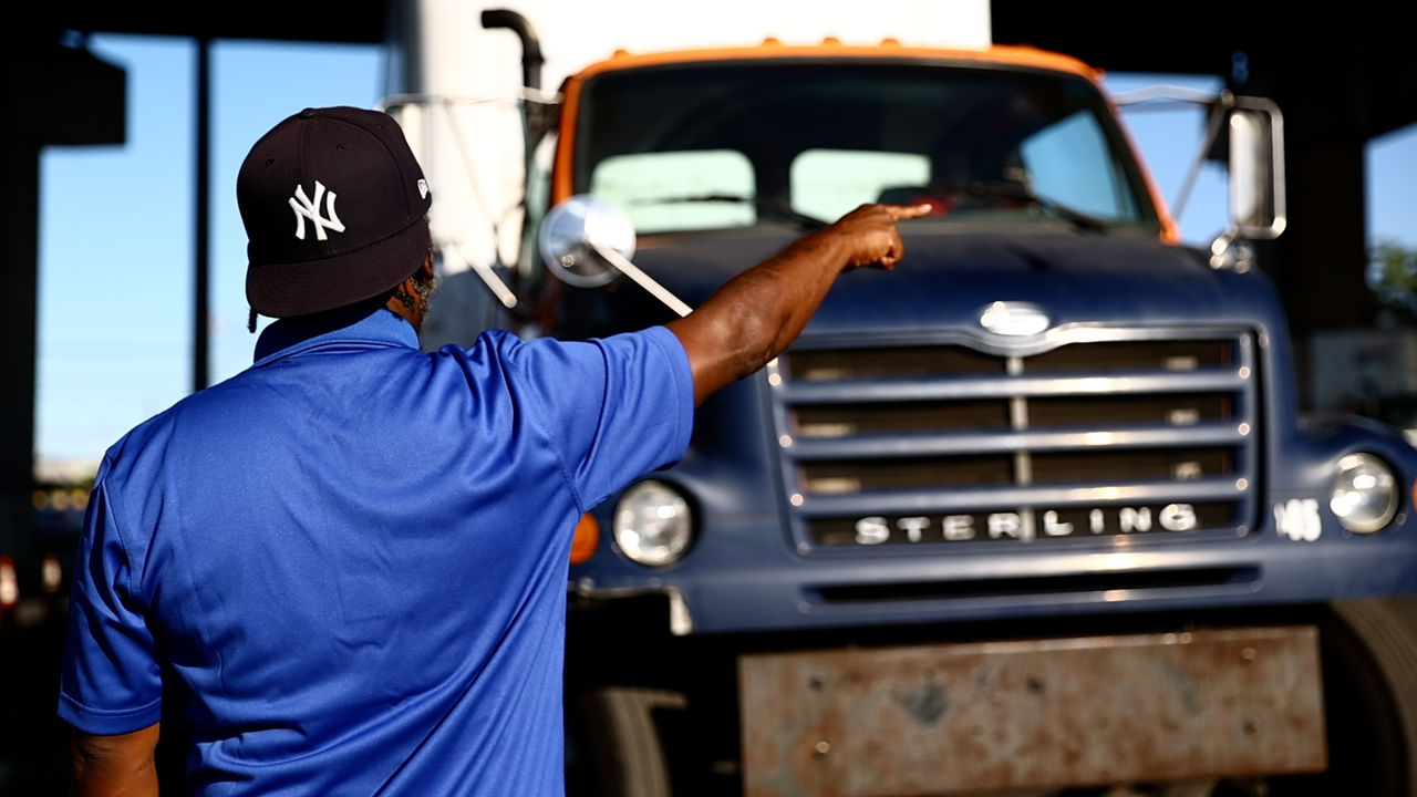 Man in blue shirt points at Sterling truck
